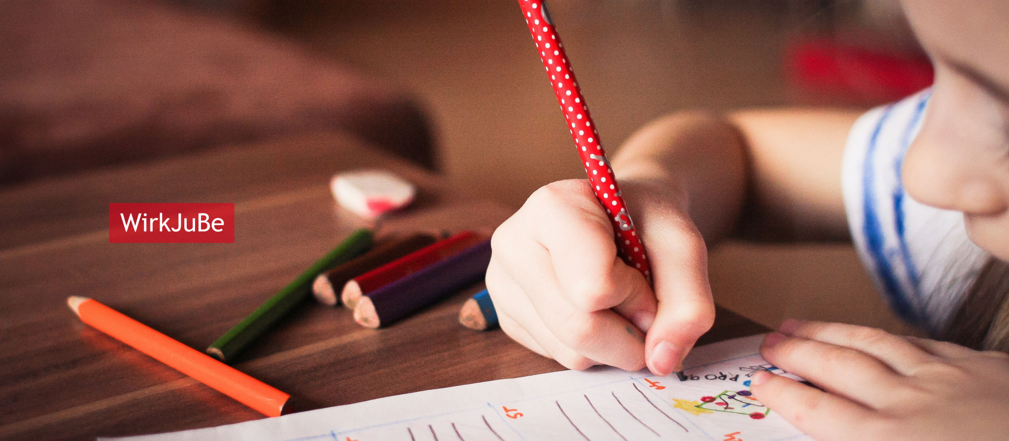 Kind malt mit Stiften auf Papier